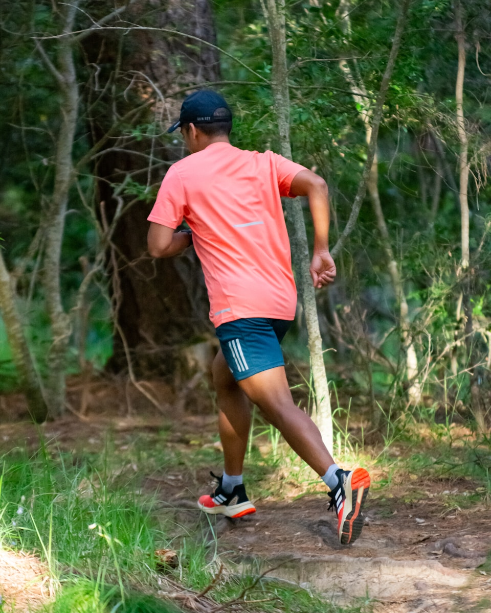 a man running in the woods on a trail