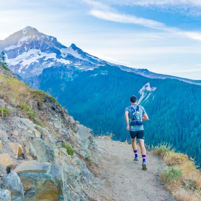 man running on edge near mountain